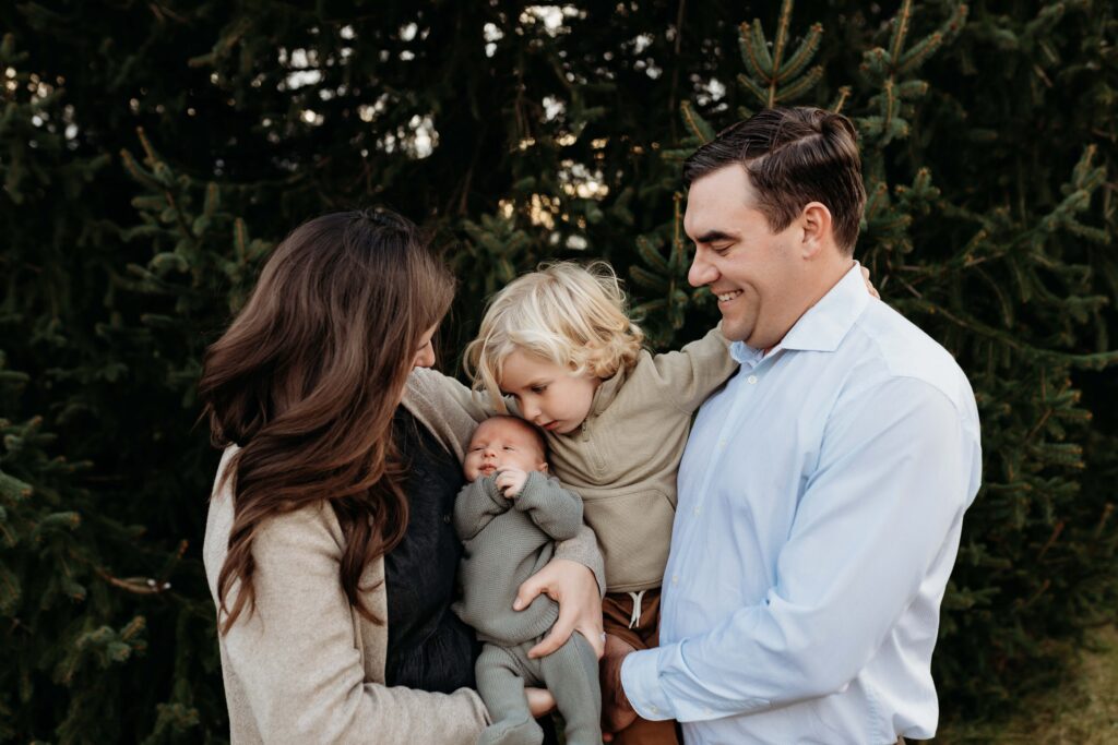 westfield family photographer's photo of a family holding a baby and toddler. They're laughing.
