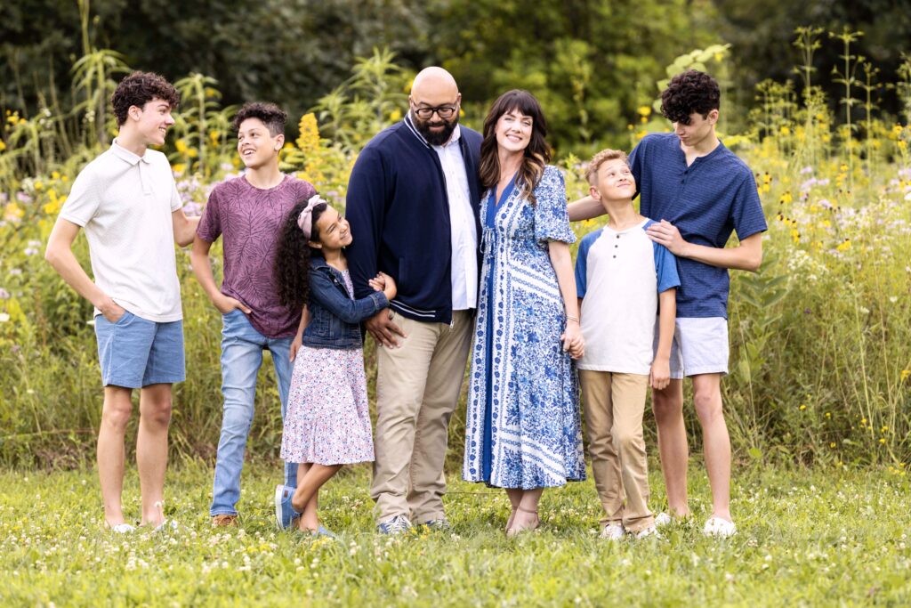 A large family together holding hands and looking at each other and smiling. Taken by a westfield family photographer.