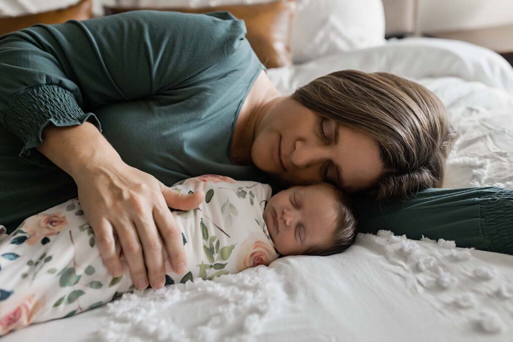 A mom lying in bed next to her newborn. Indianapolis photographer
