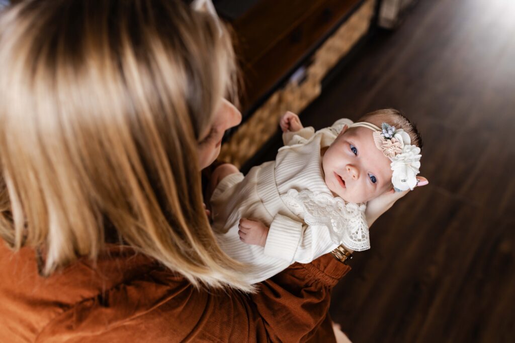A newborn baby in her mother's arms. Carmel Newborn Photographer