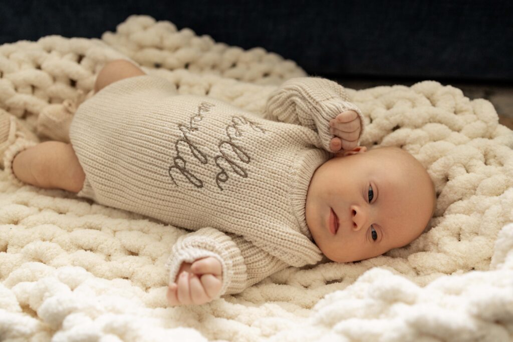 A newborn baby boy lying in a baby basket.
