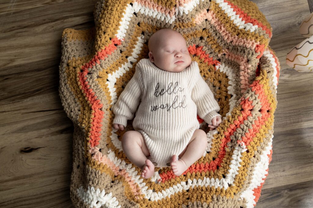 A chunky newborn baby lying in a basket with a blanket. Indianapolis newborn session.