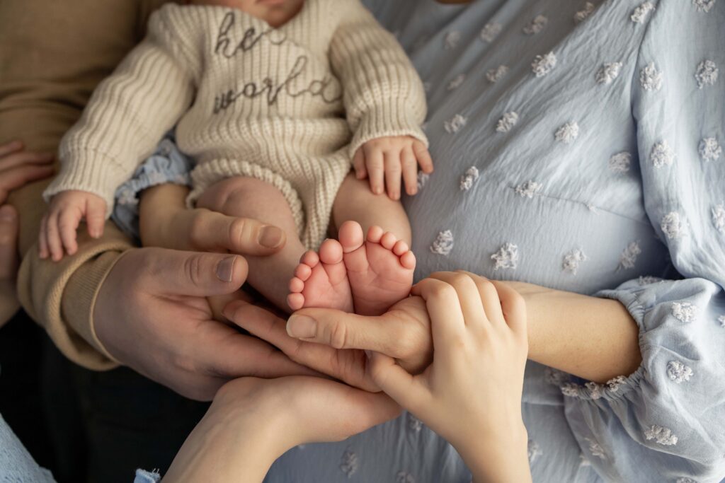Close-up photo of infant feet with the mom and dad holding them up. Indianapolis newborn session